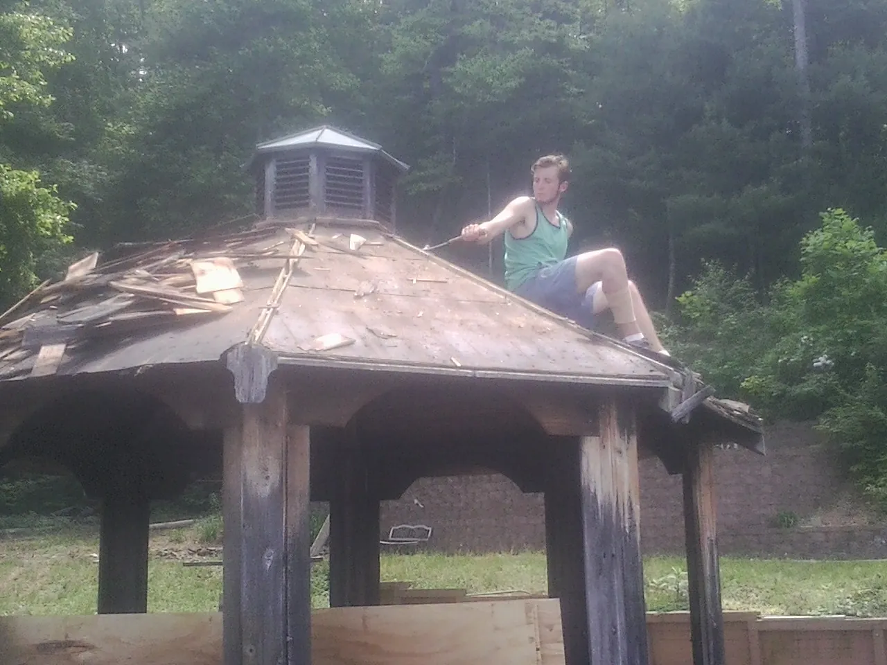 Tearing the old roof off a wooden gazebo before new shakes in Riverdale